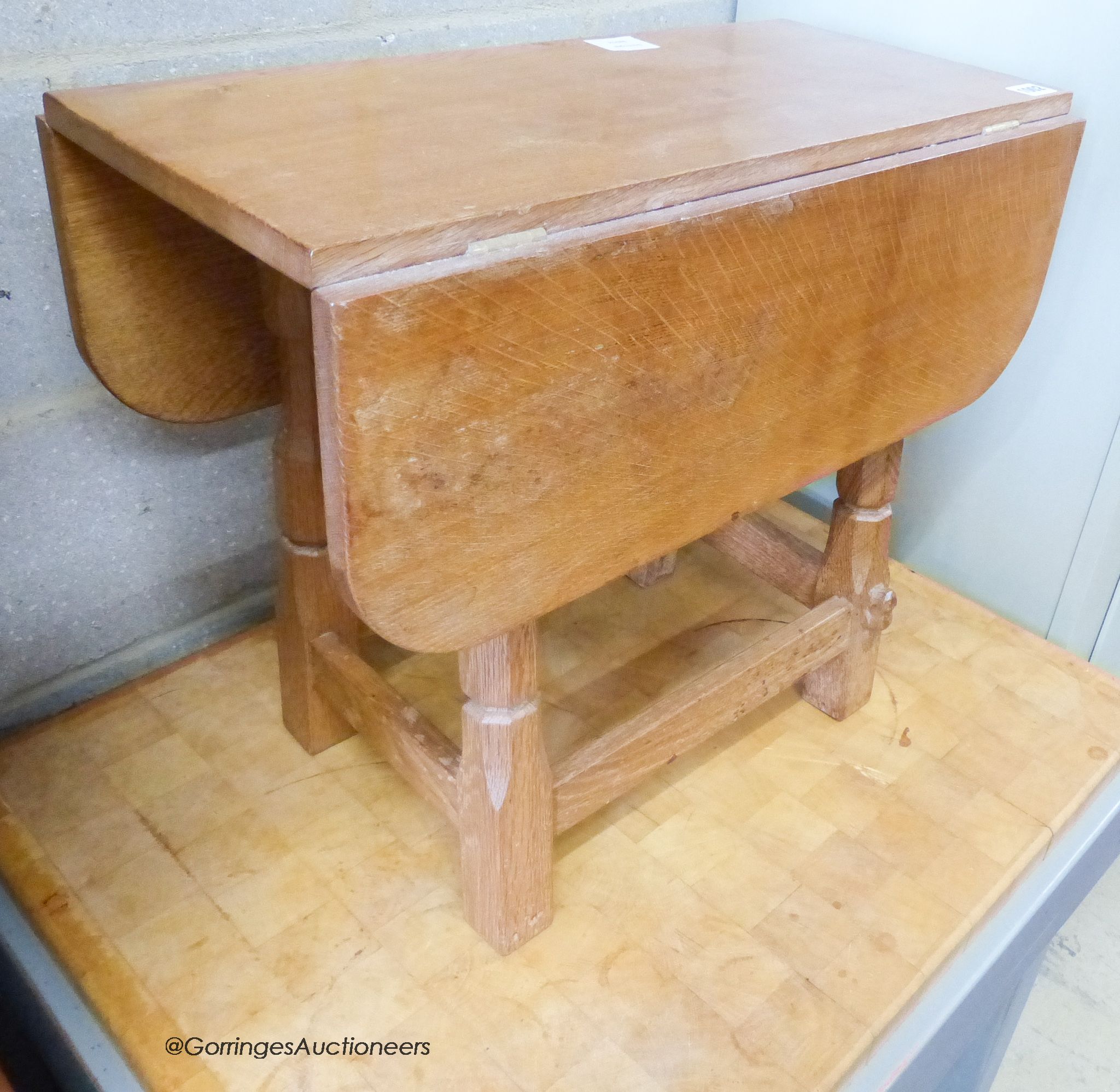 A small 'Beaverman' oak drop leaf occasional table with adzed top, 63cm extended, width 56cm, height 48cm.